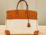an orange and white purse sitting on top of a wooden table