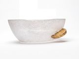 un bol en verre contenant un biscuit, posé sur une surface blanche