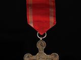 an image of a medal with a cross on it on a black background