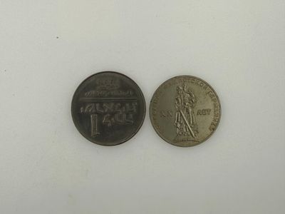 two coins that are sitting side by side on a white surface