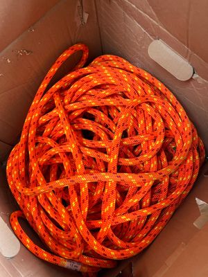 an orange rope in a box with a white tag on it