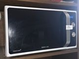 a microwave that is sitting on a shelf in a kitchen