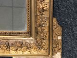 a picture of a gold framed mirror on the wall