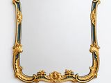 un miroir à cadre doré accroché à un mur blanc dans une pièce