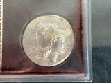 a silver coin with a picture of a woman on it