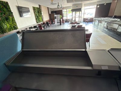 des tables et des bancs dans un restaurant avec un mur végétal