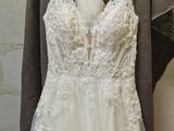 wedding dress hanging on a hanger in front of a brick wall