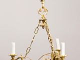 an antique brass chandelier with three candles hanging from the ceiling