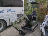 une petite pelleteuse garée à côté d'un bus