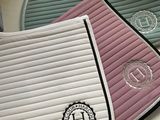 a close up of a saddle pad with a monogram on it