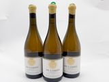 trois bouteilles de vin posées sur une table l'une à côté de l'autre