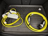 a car trunk with two yellow cords and a charger in it