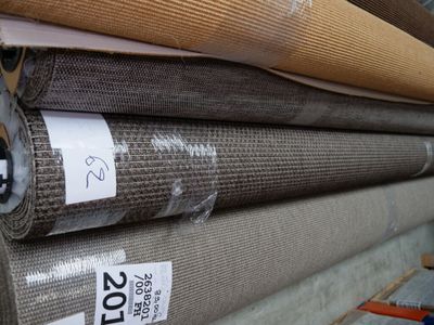 several rolls of fabric are stacked on top of each other in a warehouse