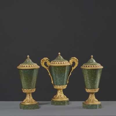 trois vases verts posés les uns à côté des autres sur une table