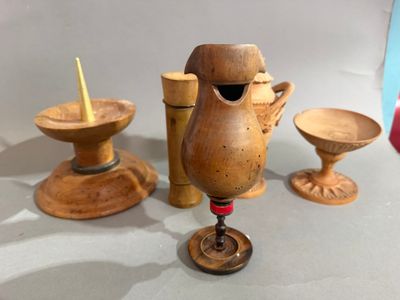 trois vases en bois et un bougeoir posés sur une table