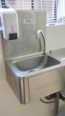 a stainless steel sink with a soap dispenser attached to it