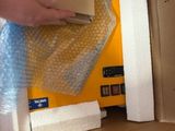 a person that is opening a box with a cell phone in it
