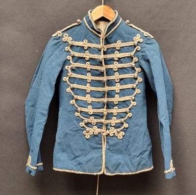 une vieille veste militaire bleue à boutons blancs, suspendue à un cintre