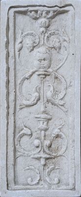 une plaque en pierre ornée d'un motif, fixée sur le mur d'un immeuble