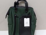 green and black handbag with a tag on it sitting on a table