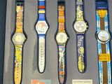 five watches displayed in a display case on a table
