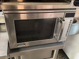a microwave that is sitting on a stand in the kitchen