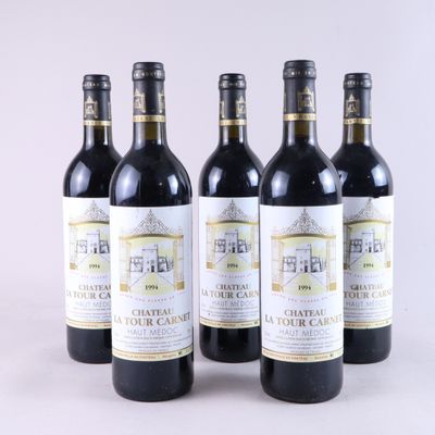 quatre bouteilles de vin sont alignées sur une surface blanche