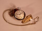 a pocket watch with a chain around it on a table