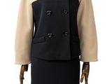 Le mannequin porte une robe et un manteau noirs et beiges.