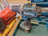 une perceuse posée sur une boîte à outils