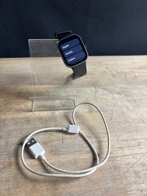 an apple watch is connected to a charger on a wooden table