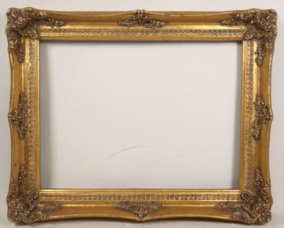 a gold picture frame with ornate carvings and a white background