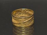 a gold ring that is sitting on a black surface