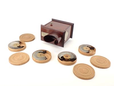 une petite boîte en bois sur laquelle sont posés quelques vieux disques