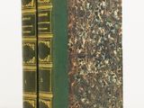 two green books sitting on top of each other on a white surface