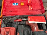 une boîte à outils rouge contenant des outils, posée sur une table