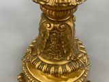 gold plated candle holder with a bird on top of it