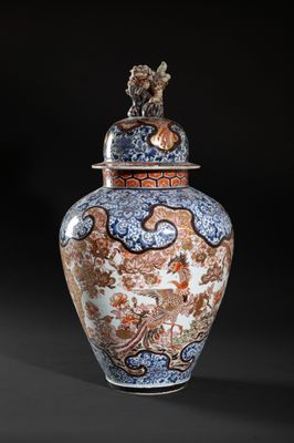 an orange and blue vase with a bird on top of it