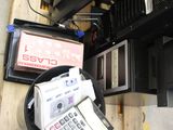 a pile of electronic equipment on a pallet next to a fan