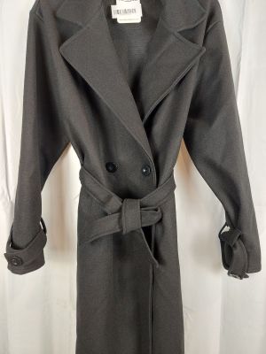 a grey coat is hanging on a hanger in front of a white curtain