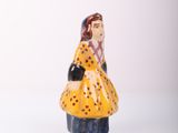 a small figurine of a woman in a yellow dress