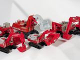 cinq camions rouges miniatures alignés sur une surface blanche