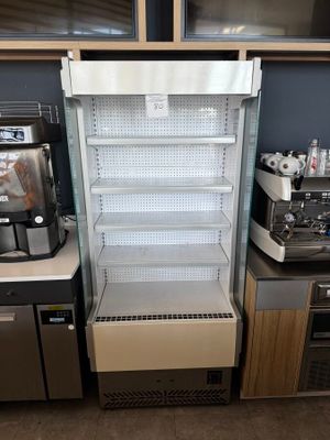 un réfrigérateur situé à côté d'un plan de travail sur lequel se trouve une machine à café