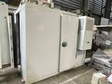 un réfrigérateur blanc posé dans un entrepôt à côté d'autres appareils électroménagers