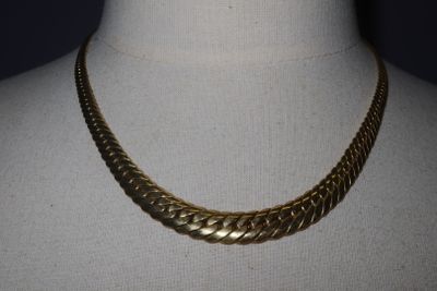 a close up of a gold necklace on a mannequin mannequin