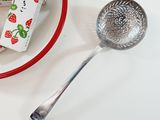 a piece of cake on a plate next to a measuring spoon