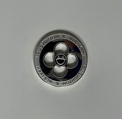 a close up of a silver coin with a flower on it
