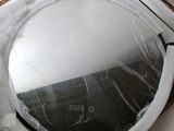 a round mirror sitting on top of a washing machine