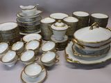 a lot of white and gold dishes and cups