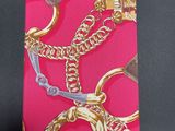 a pink card with a gold chain and a pair of scissors